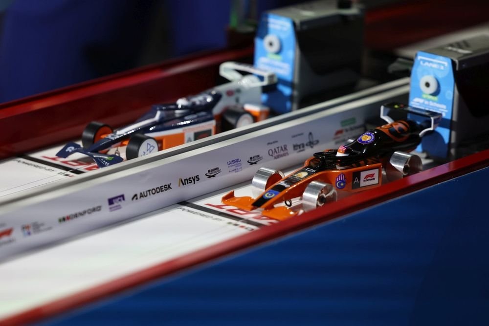 Two STEM Racing cars lined up on the track lane before a run